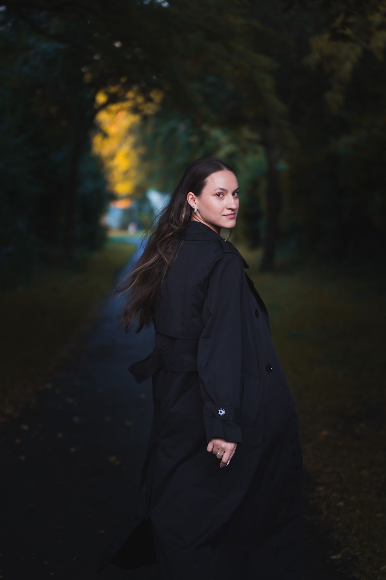 Turning back on a dark tree-lined path, the coat swinging.